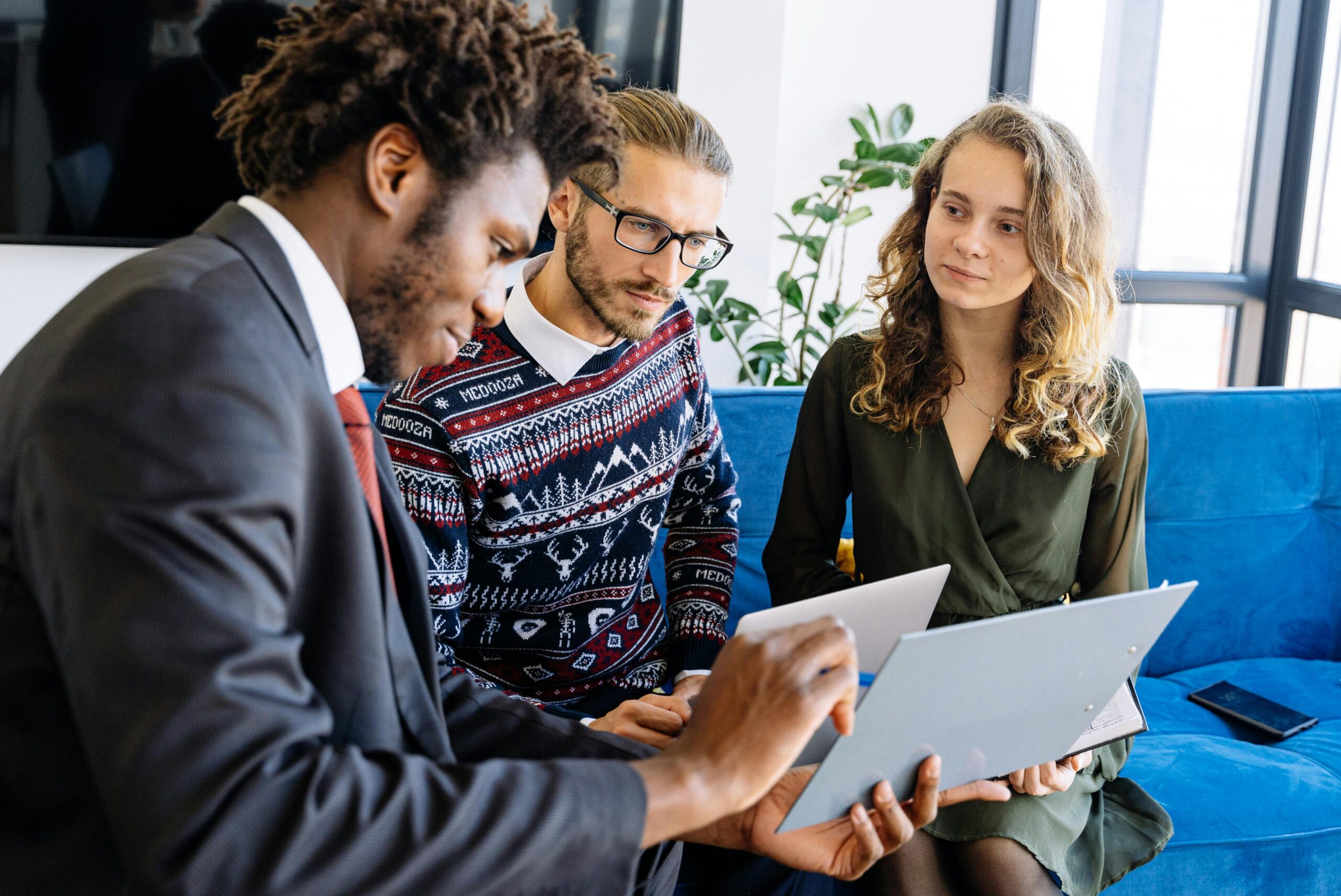 A diverse group of young professionals engaged in a business meeting inside a modern office.